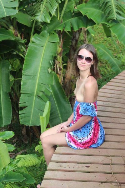 Обнаженная красотка прогуливается по скверу