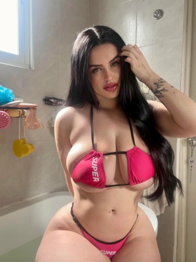 Горячая брюнетка демонстрирует свои волнующие изгибы и огромные "прелести"