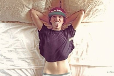 Обнаженная красотка с яркими татуировками на теле