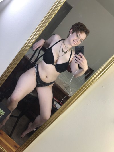 Красотка позирует перед зеркалом, показывая свои аппетитные формы и прекрасное декольте