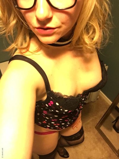 Сексуальная красотка с бровями позирует перед зеркалом, демонстрируя свои прелести и снимает себя на смартфон