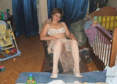 Раздетая молодая мамочка расслабляется на кровати в уединении