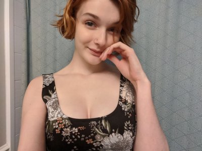 Горячая красотка с красными волосами фоткается дома перед зеркалом в полумраке