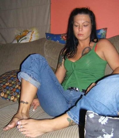 Развратная красотка с татуировками в искусной позе оголяется