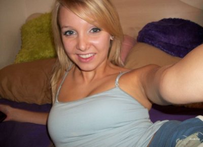 Очаровательная блондинка сбрасывает одежду на уютной кровати