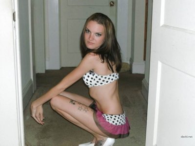 Молодушка с рисунком на коже показывает свои прелести, раздвигая ноги