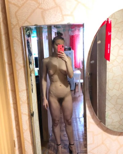 Девушка с пирсингом на груди наслаждается носком прозрачных носочков