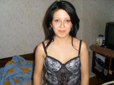 Сексуальная брюнетка в откровенной позе на уютной кровати