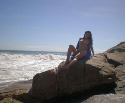 Брюнетка на отдыхе стягивает одежду и позирует без неё, демонстрируя свои шикарные формы