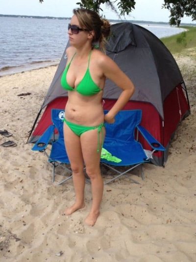 Обнаженная девушка отдыхает на пляже с шатром
