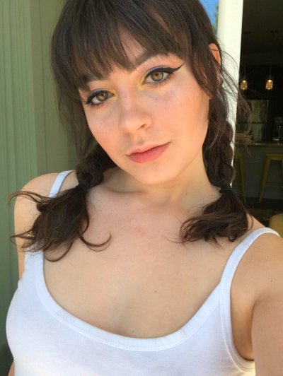 Темноволосая девушка делает снимки своей попки