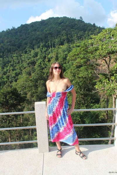 Обнаженная красотка прогуливается по скверу