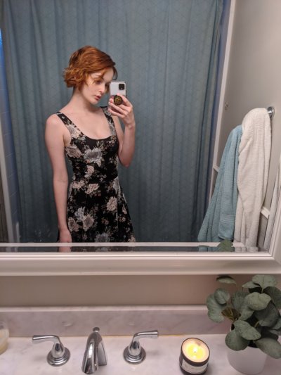 Горячая красотка с красными волосами фоткается дома перед зеркалом в полумраке