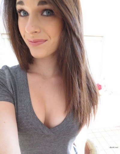 Привлекательная красотка с очаровательным взглядом позирует на камеру