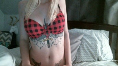 Изображения молодой светловолосой дамы с многочисленными рисунками на теле