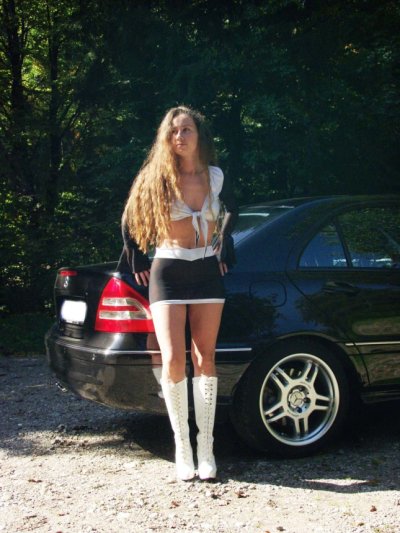 Сексапильная дама позирует возле авто, демонстрируя свои изгибы