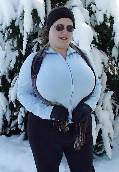 Шлюшка вываливает свои огромные сиськи на морозе и греет их варежками.