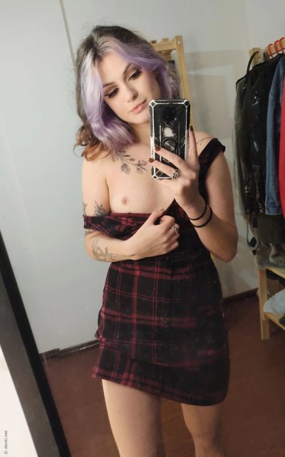 Привлекательная красотка с татуировками делает фото, показывая свое тело и аппетитные формы