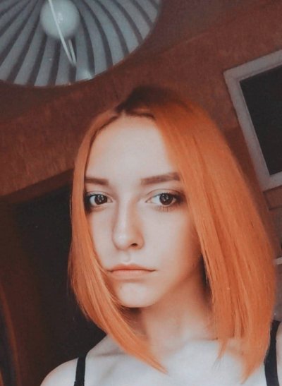 Рыжая красотка без одежды стоит в позе собачки