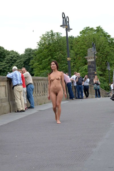 Очаровательная азиатка наслаждается прогулкой по улице без одежды