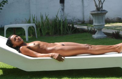 Экзотичная красотка с обнаженным телом наслаждается солнцем.