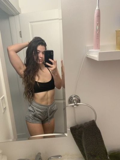 Молодая шатенка позирует на камеру, показывая свои прелести