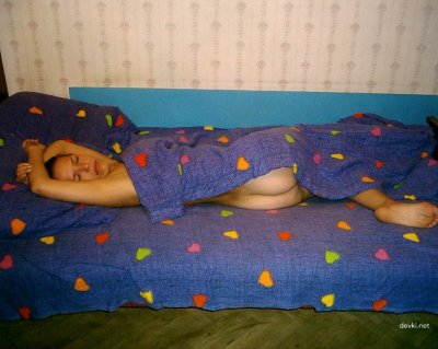 Милашка без одежды расслабляется на кровати