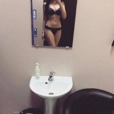 Снимает себя без одежды в отражении стекла