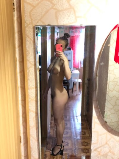 Девушка с пирсингом на груди наслаждается носком прозрачных носочков