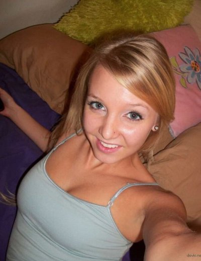 Девушка с яркими татуировками и пирсингом показывает свои прелести