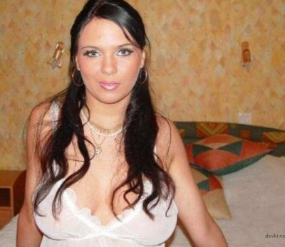 Брюнетка в белом платье эффектно демонстрирует свою красоту без одежды