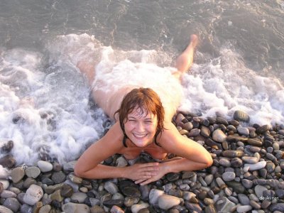 Мужчина фотографирует свою полуголую подругу на пляже