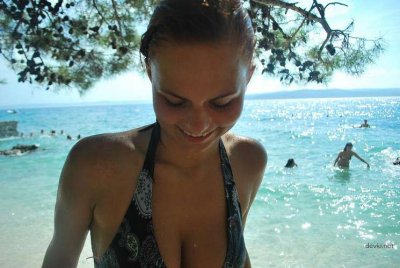 Барышня нежится в воде и смачно позагорает без лифчика