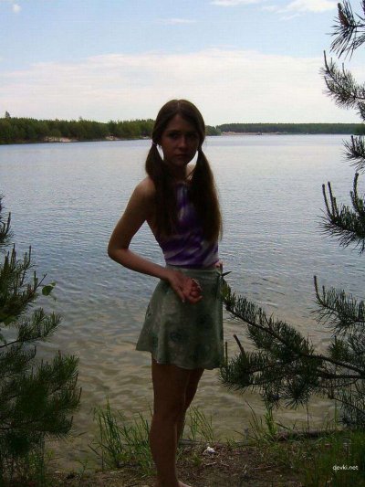 Молодая скромная красавица без одежды наслаждается отдыхом на пляже