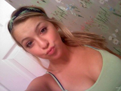 Молодая красавица позирует обнаженной перед зеркалом, демонстрируя свои прелести.