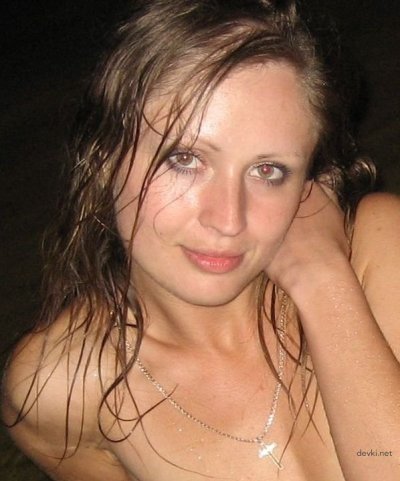 Молоденькая красавица расслабляется, плескаясь обнаженной в темной воде реки