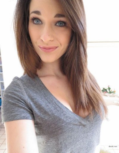 Привлекательная красотка с очаровательным взглядом позирует на камеру