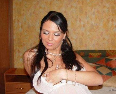 Брюнетка в белом платье эффектно демонстрирует свою красоту без одежды