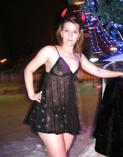 Дама показывает свои прелести возле новогодней елки