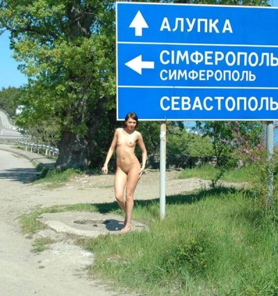 Обнаженная красотка возле дорожного знака