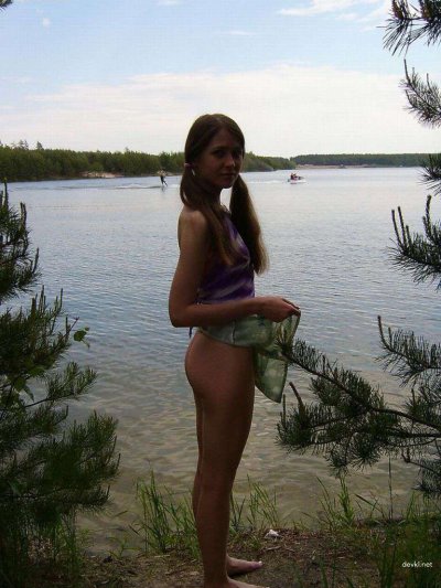 Молодая скромная красавица без одежды наслаждается отдыхом на пляже