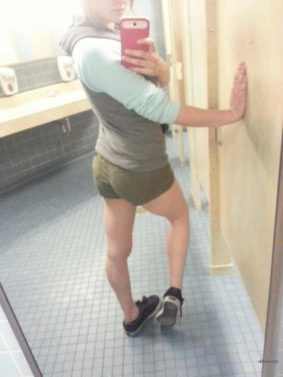 Молодая красотка позирует в учебном уборном