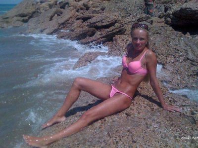 Сексуальная блондинка наслаждается отдыхом на пляже у моря