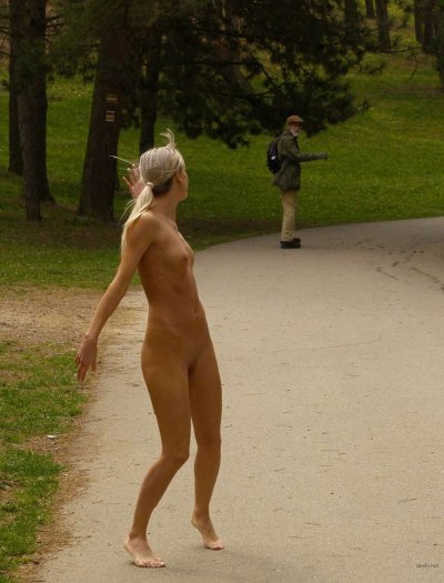 Нагая блондинистая красотка прогуливается по парку в поисках приключений.