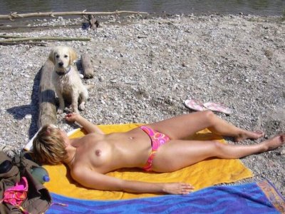 Дама без лифчика загорает на берегу