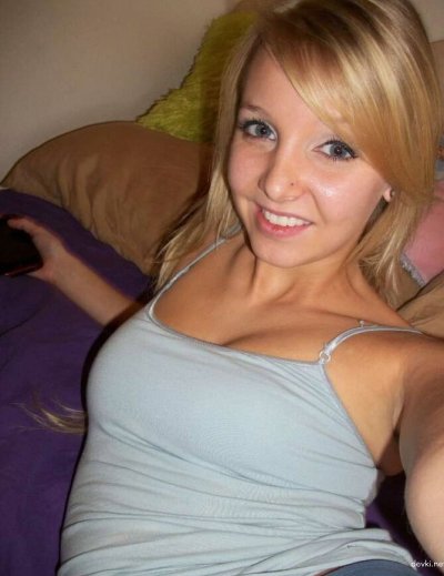 Девушка с яркими татуировками и пирсингом показывает свои прелести