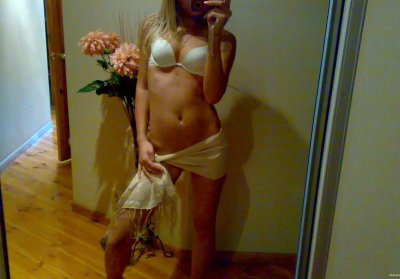 Девушка фоткается перед зеркалом в откровенном наряде