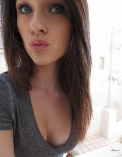 Привлекательная красотка с очаровательным взглядом позирует на камеру