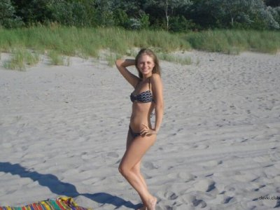 Сексуальная девушка позирует без одежды на морском берегу