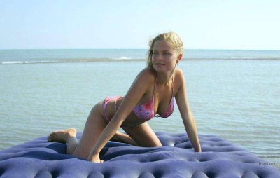 Очаровательная девушка наслаждается солнечными днями на пляже без купальника